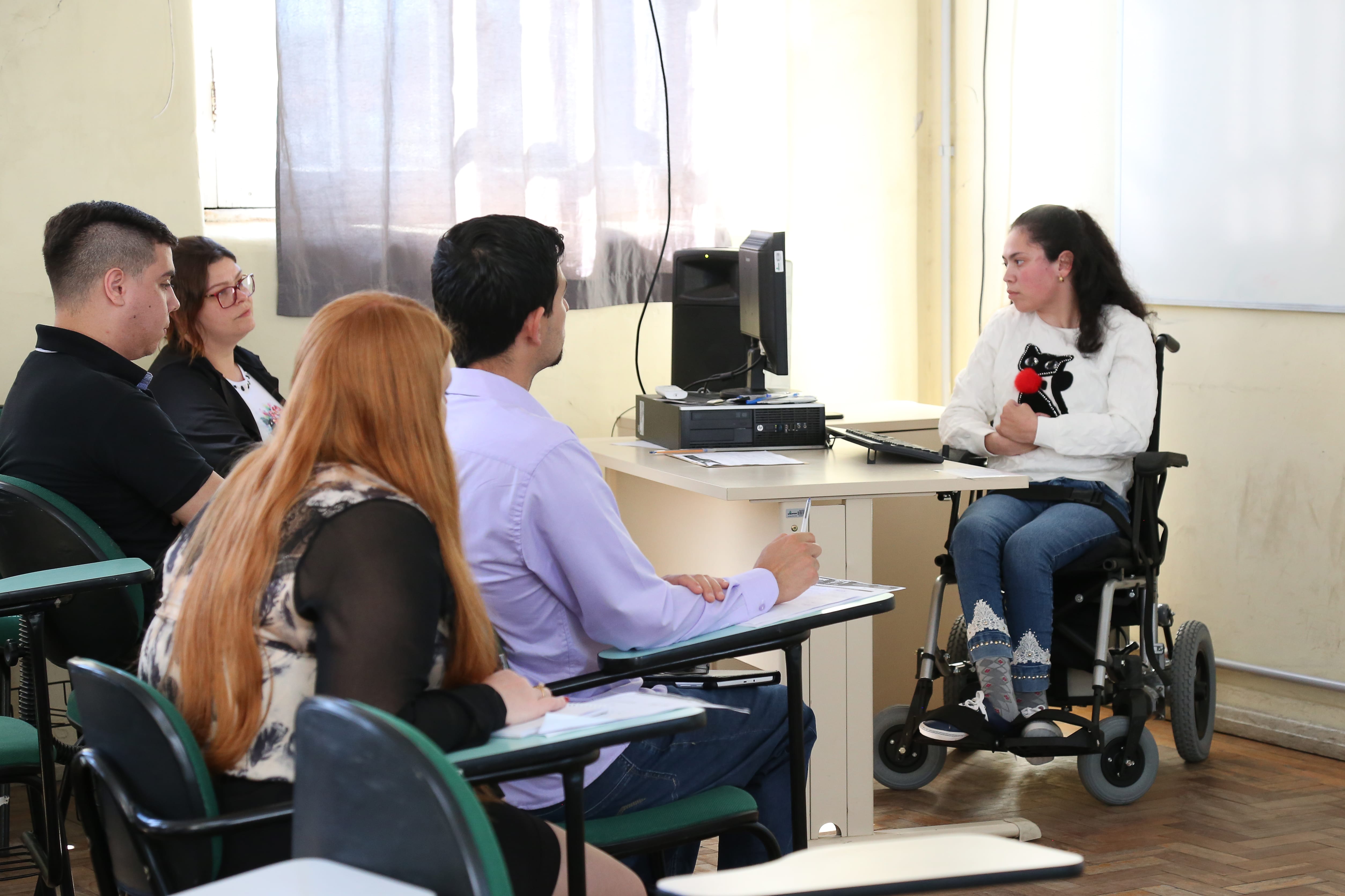 Estudante da Unipampa, que utiliza cadeira de rodas, apresenta trabalho sobre acessibilidade em seminário. Crédito: Milene Marchezan.